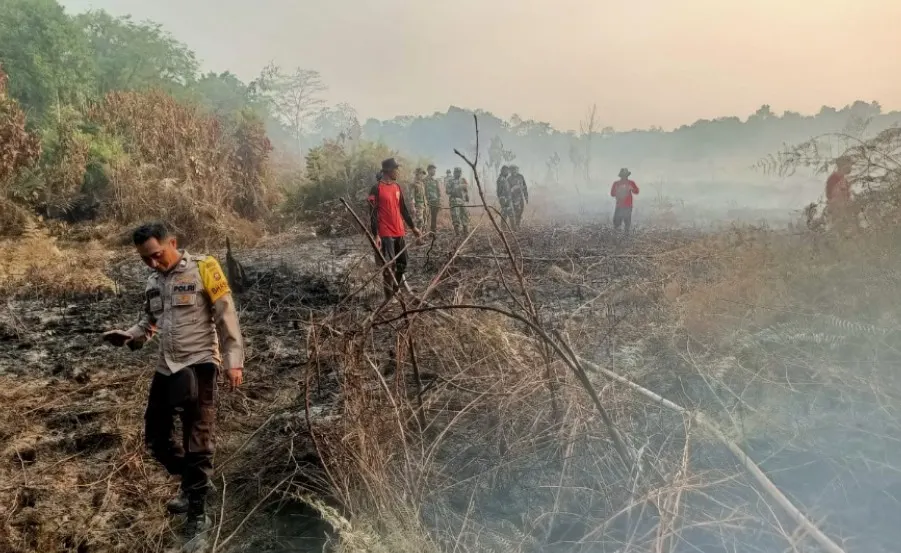 Aparat kepolisian dan TNI bahu membahu bersama masyarakat memadamkan api akibat kebakaran lahan di Desa Medan Mas, Kecamatan Batu Ampar, Kubu Raya.